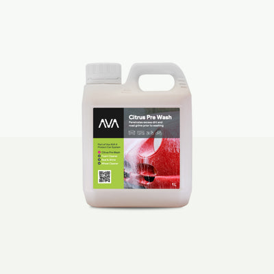 A 1 litre white plastic jug with handle and white screw cap, labelled ‘AVA Citrus Pre Wash’ with a green and black design, showing a close‑up image of a red car’s wheel arch and body panel.